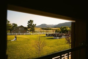 Denver Wedding Photography at Crooked Willow Farms shot from the bar as bride walks down the aisle with father