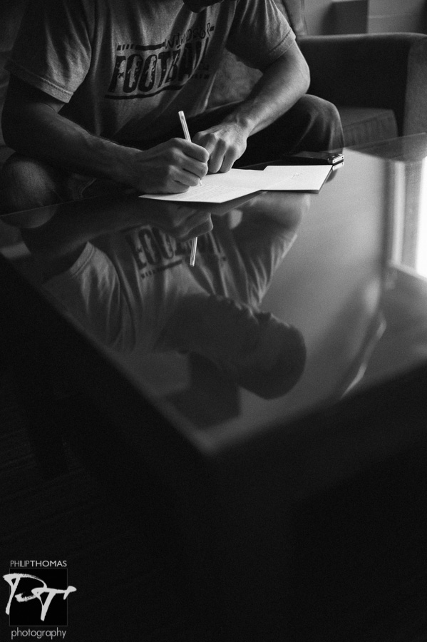 Groom writing letter. Photo by Philip Thomas Photography