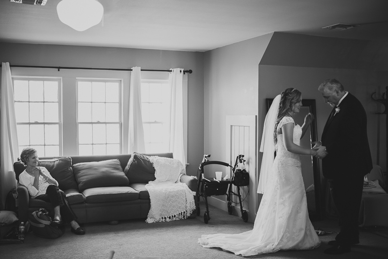 father of the bride embraces daughter as grandmother smiles