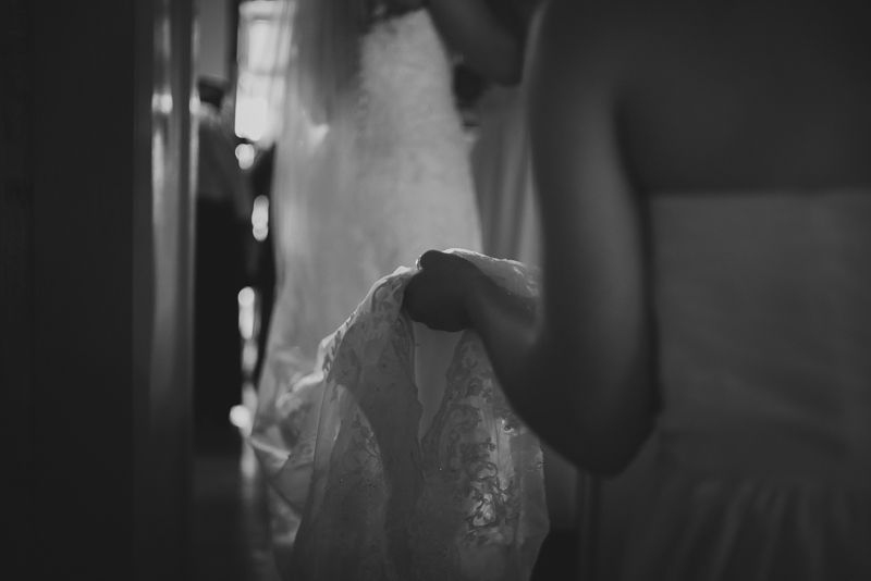 a bridesmaid holds the corner of her dress