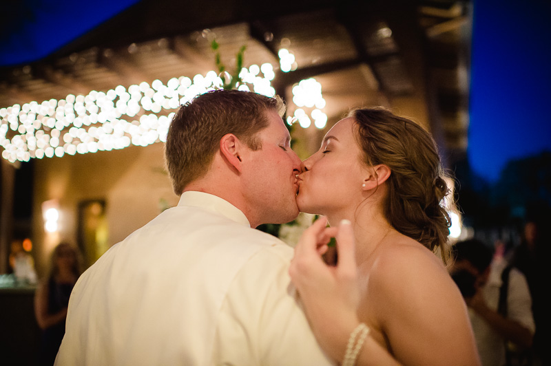Couple enjoy a kiss during cake cutting