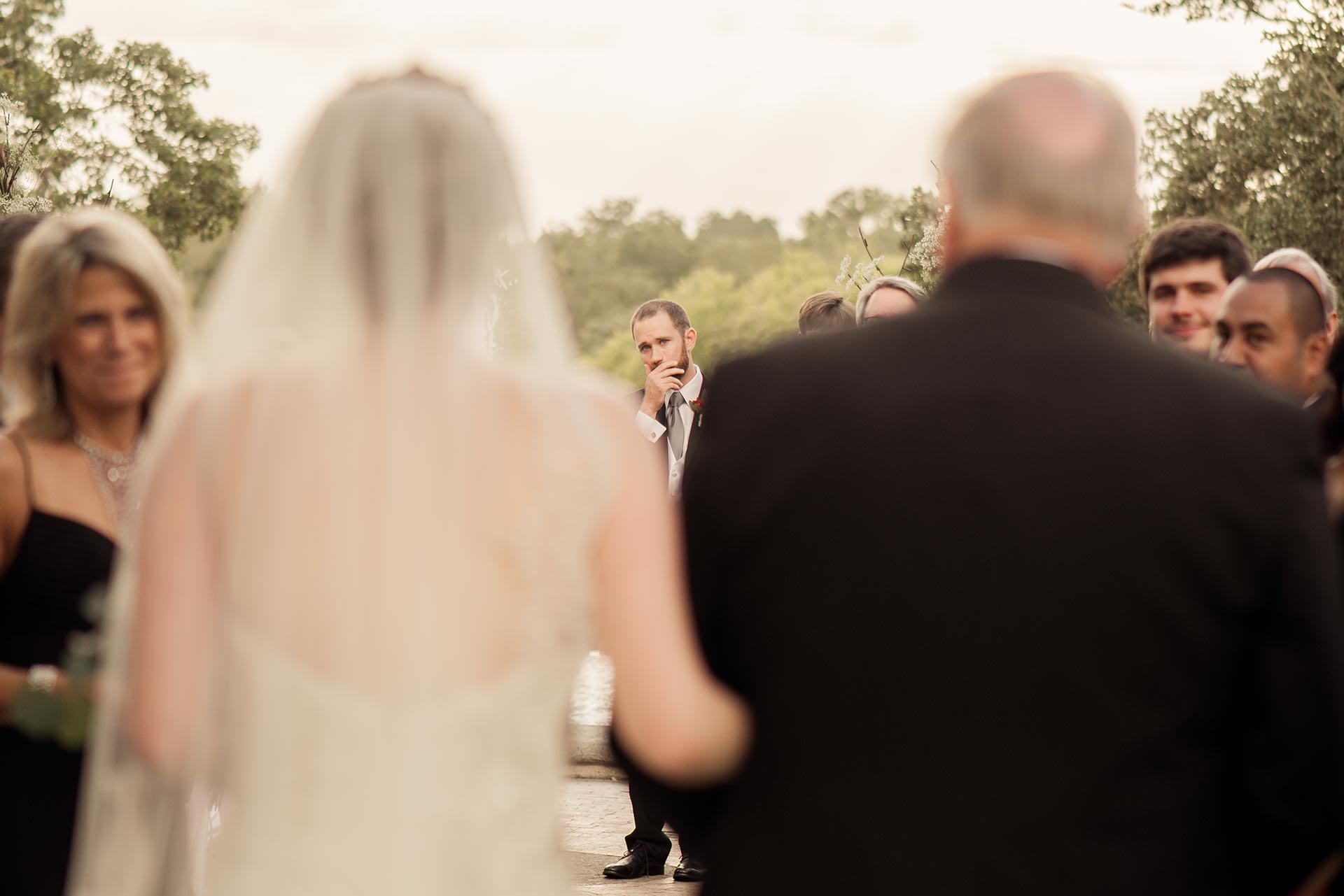 Groom breaks his stout turing to a gasp of emotion seeing his bride come down the aisle at the McNay Art Museum, San Antonio Texas