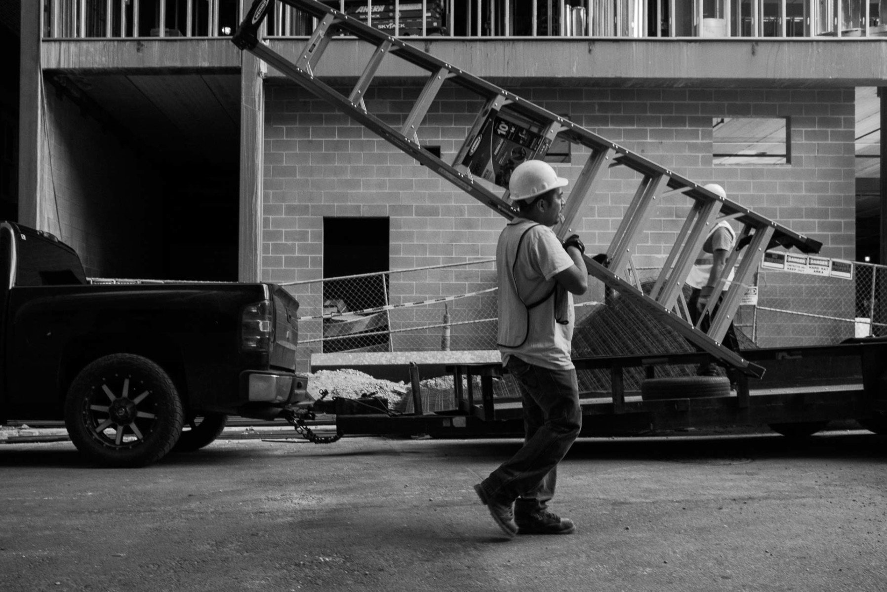 A construction worker carries a ladder on his shoulder Leica Street Photography Philip Thomas