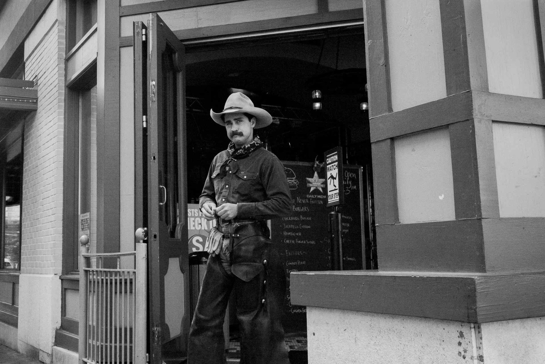 A man dressed in cowboy uniform poses outside a tourist store in San Antonio texas Street Photography San Antonio Texas
