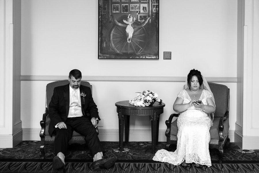 The Westin Hill Country wedding reception as couple sit and look bored photographed by San Antonio based wedding photographer Philip Thomas