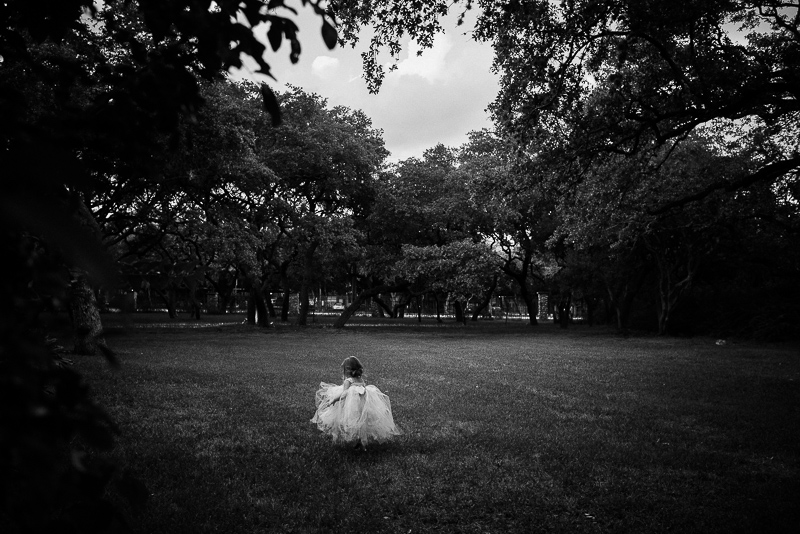 A little girl walks into a field at The Verandah San Antonio Leica Wedding Photographer - A 100 Weddings Later by Philip Thomas