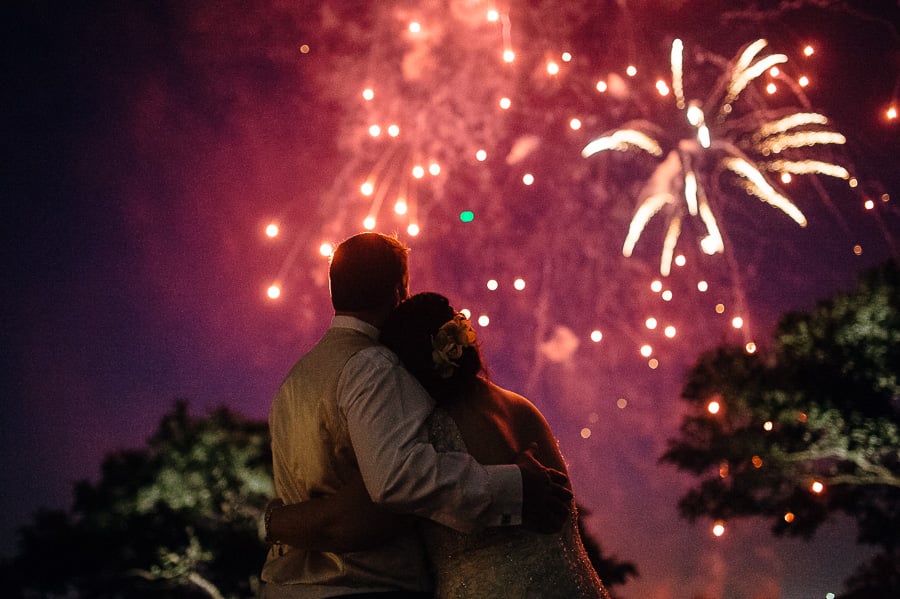Couple hug as July 4th fireworks explode in the sky at a Wedding Hyatt Hill Country Resort, San Antonio