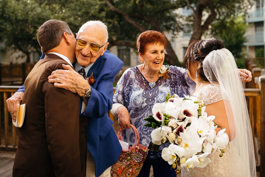 Grandparents hug bride and groom July 4th Wedding Hyatt Hill Country Resort, San Antonio