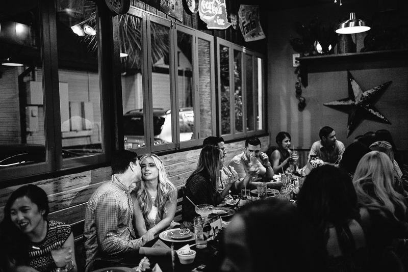 Groom whispering to bride during rehearsal dinner