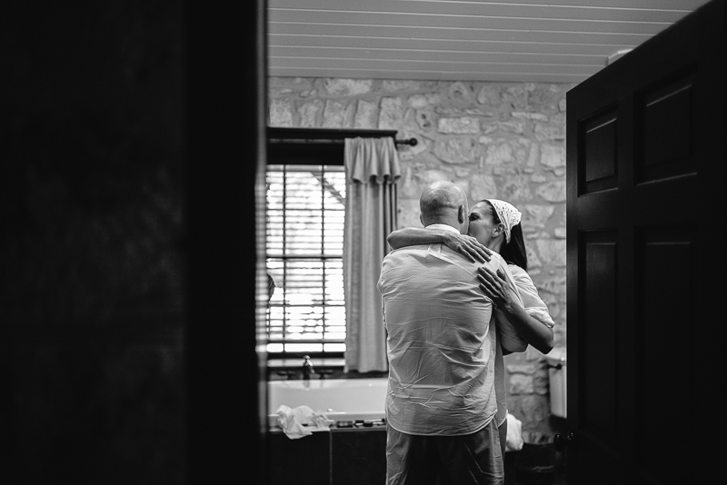 Style Me Pretty - Couple discreetly kissing moments before groom and bride start getting ready