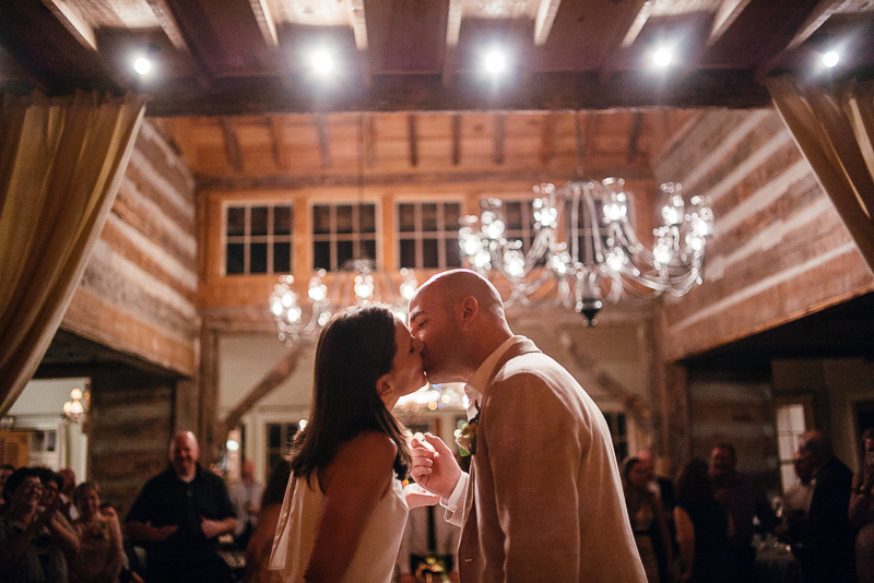 Bride and groom kiss after cutting the cake - wedding reception Hoffman Haus