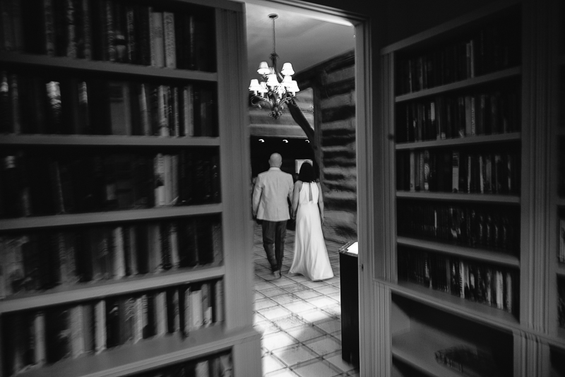 Bride and groom walk from the library during their wedding reception at Hoffman Haus