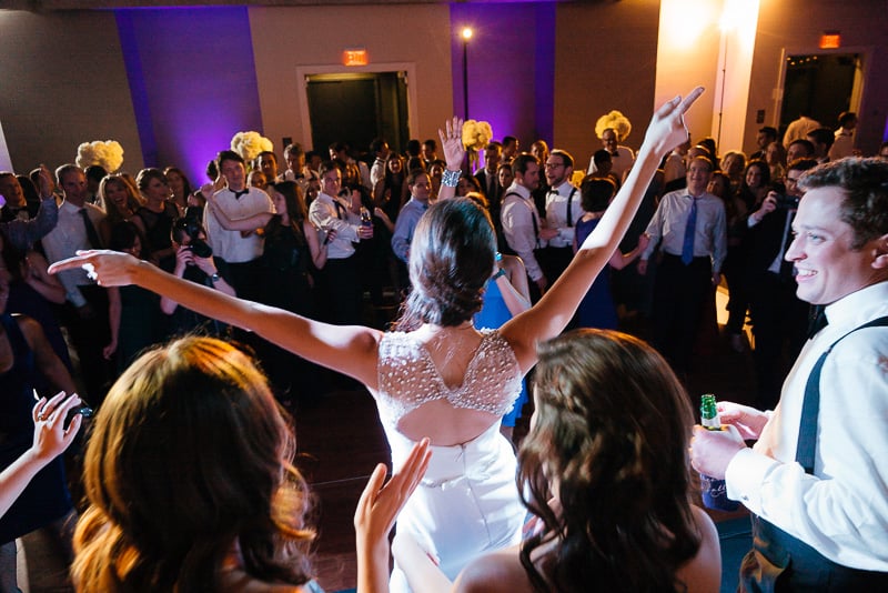 Bride with arms outstretched on ballroom stage