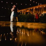 Father of the bride dancing wth bride in rain water reflection