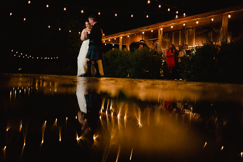 Father of the bride dancing wth bride in rain water reflection