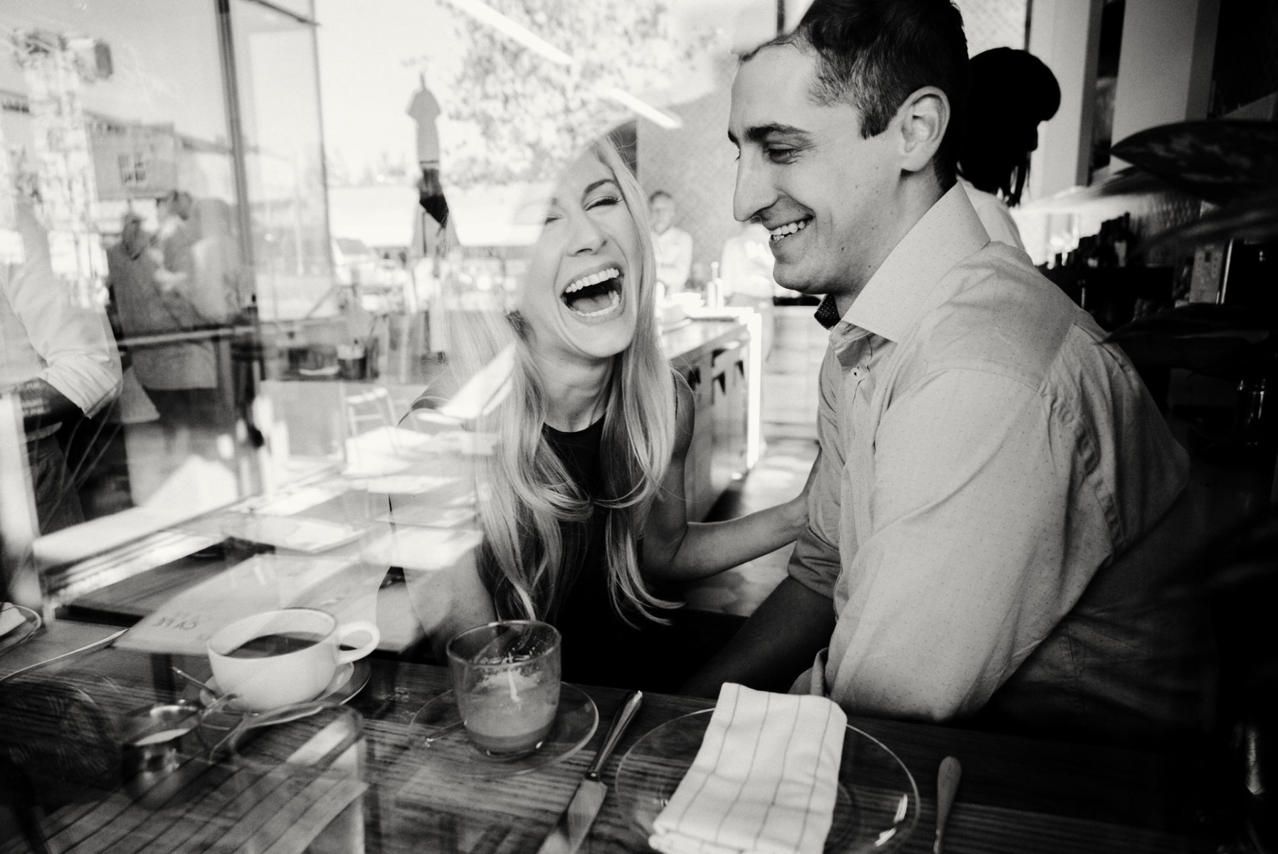 Engaged couple laugh sharing a joke at a coffee shop in Austin Texas