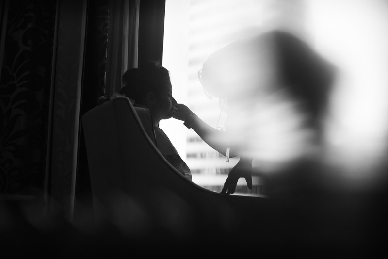 Bride silhouetted during makeup at Omni Houston Hotel