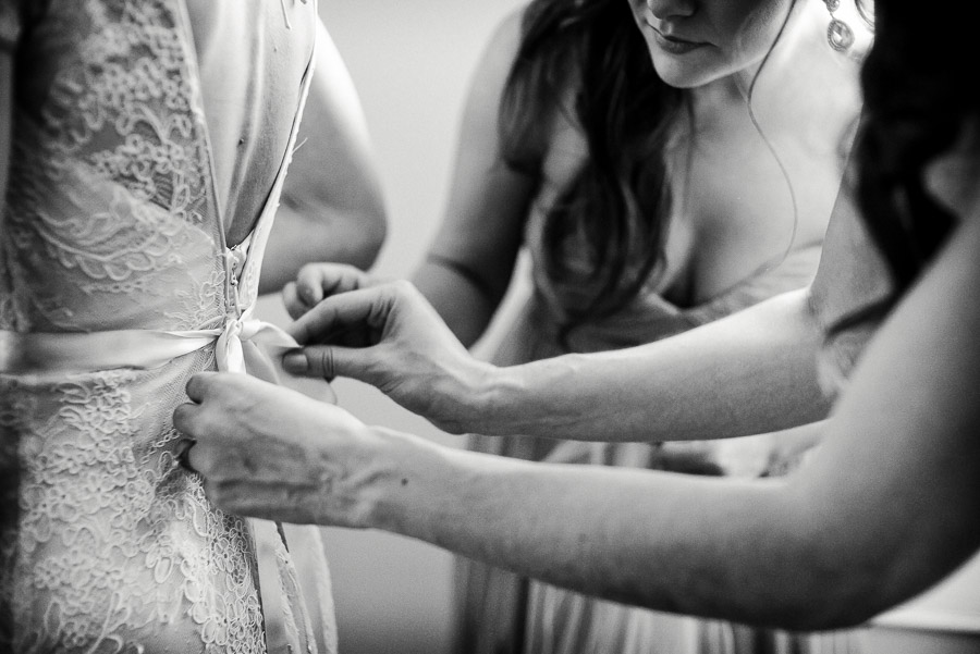 tying the back of brides dress