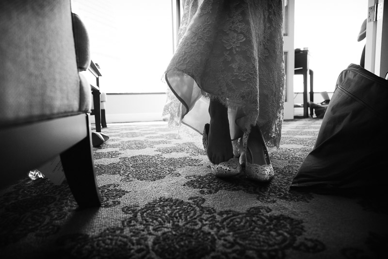 Bride puts shoes on at Omni Houston Hotel