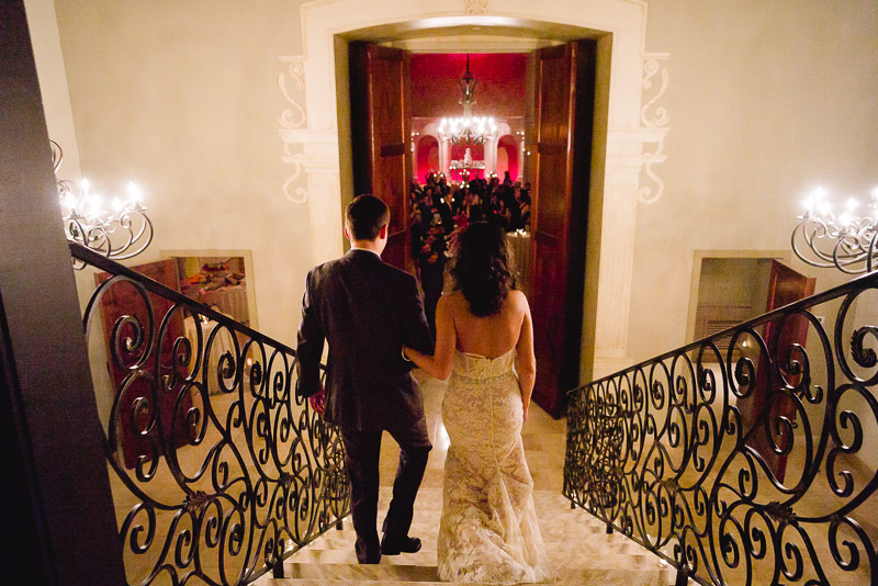 Couple walk down staircase entering wedding reception at The Bell Tower on 34th, Houston.