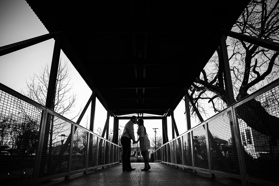 Couple engaged on bridge silohetted