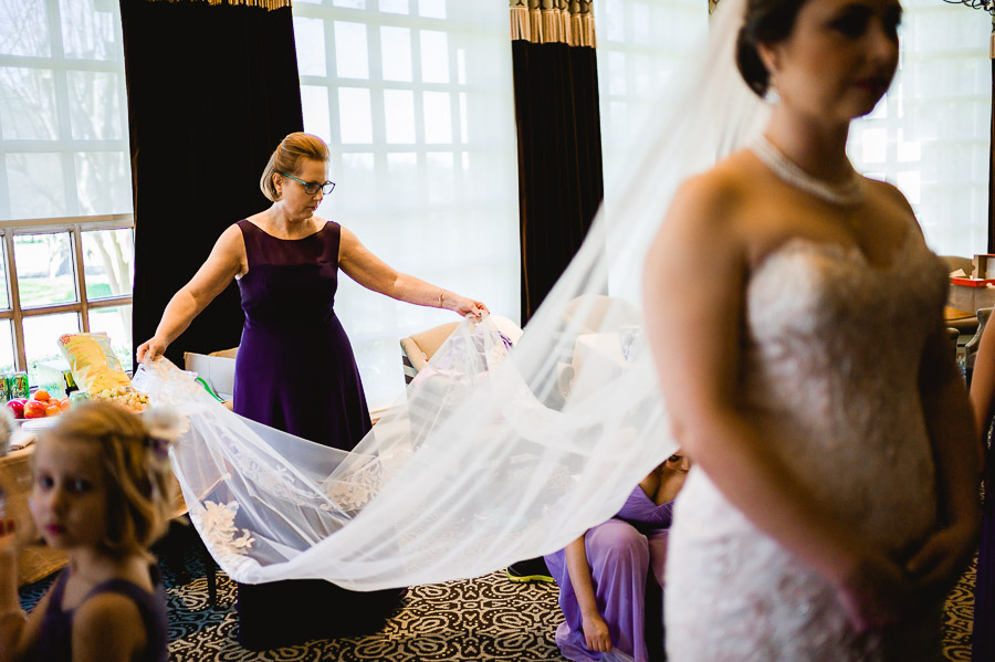 Mother of the bride fluffing the veil