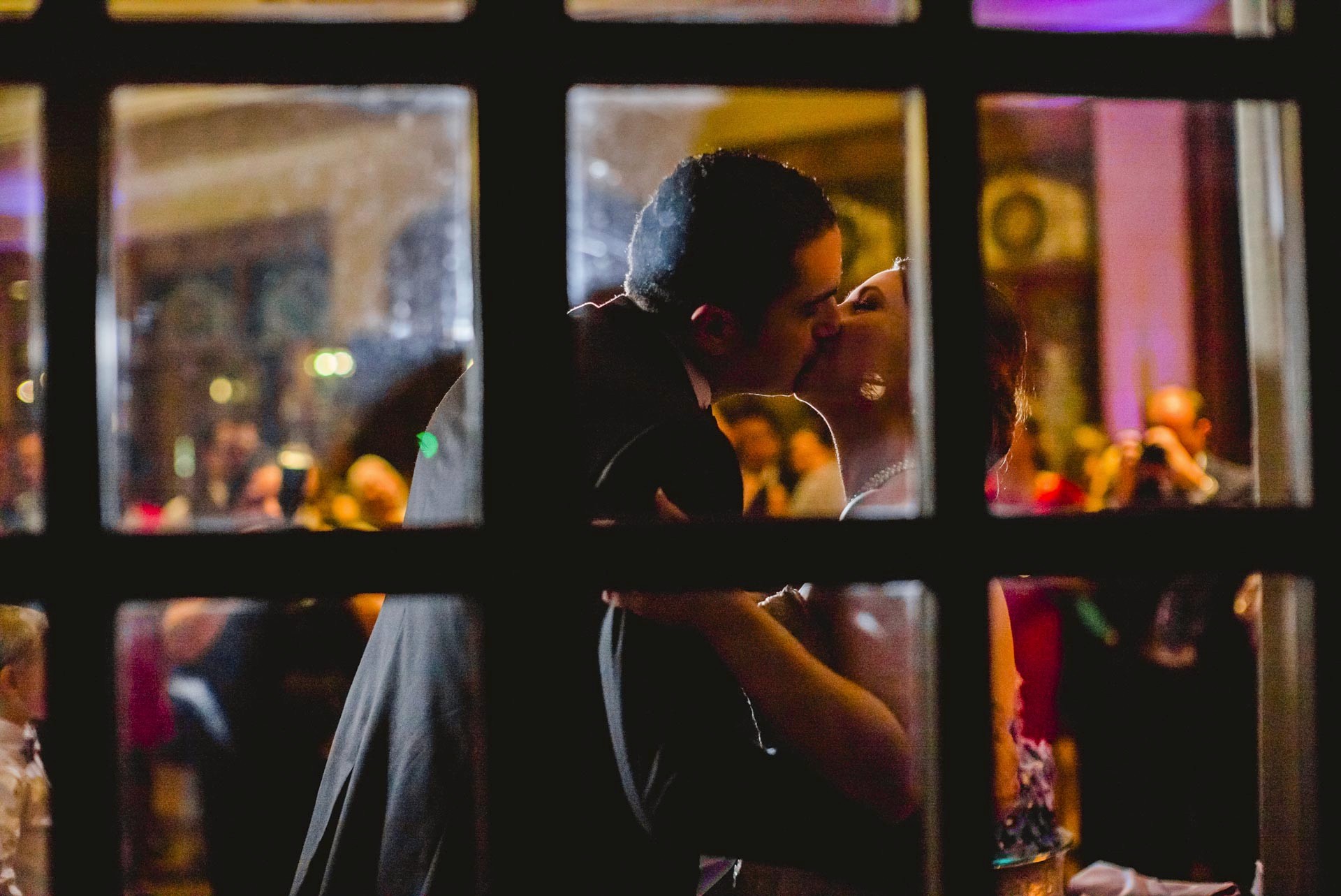 Couple kiss within a window frame at The Dominion, San Antonio, Texas