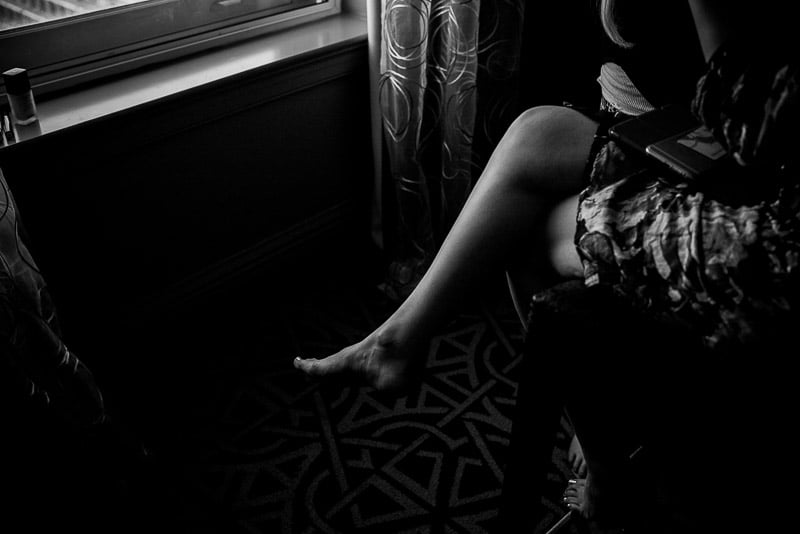 Brides legs crossed against the light in hotel room Houston Fire Station 3-Wedding photographer-Philip Thomas