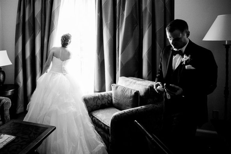 WPJA award winning image - Wedded couple arrive in hotel room brides looks out of window