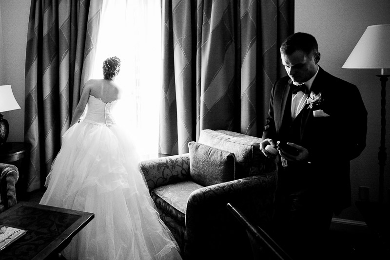 WPJA award winning image - Wedded couple arrive in hotel room brides looks out of window