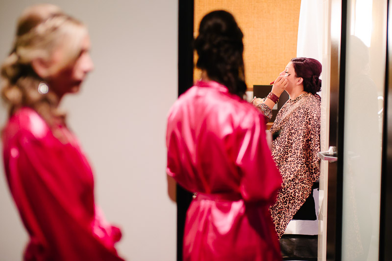 Bride makeup with bridesmaids looking on at The Valencia hotel, San Antonio