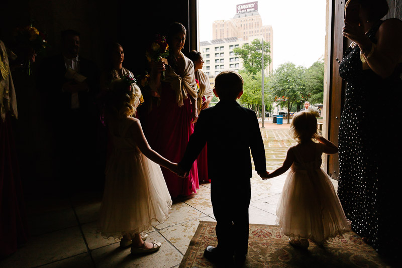 Flower girl and ring bearer holding hands at San Fernando Cathedral pre wedding ceremony, San Antonio, Texas
