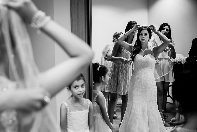 Bride checks in mirror final touches as her young daughter looks Spring wedding St Anthony + Los Encinos-Wedding photographer-Philip Thomas