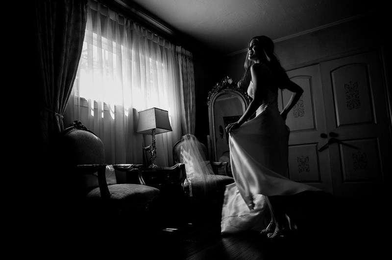 Bride picks up her dress and turns near window Madera Estates-Philip Thomas