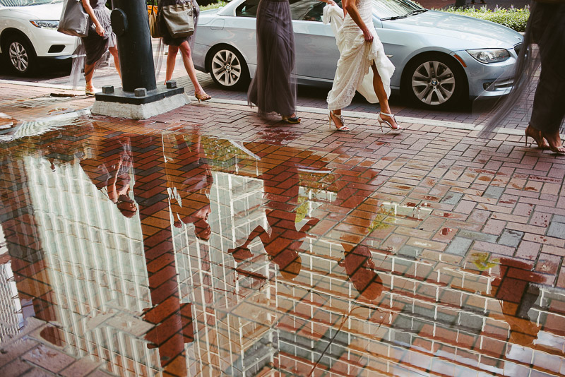 Bride walk pass a water reflection on the sidewalk in Houston -Philip Thomas