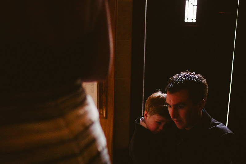 Father and young son in low light hug at St. Paul's United Methodist Church Houston wedding