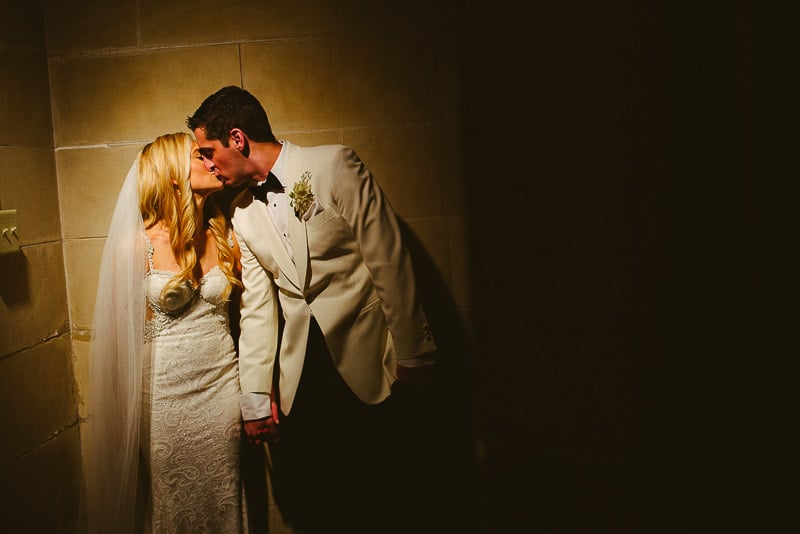 Groom leans into bride with available light to kiss bride at St. Paul's United Methodist Church Houston Wedding-Hobby Center Wedding Houston-Philip Thomas