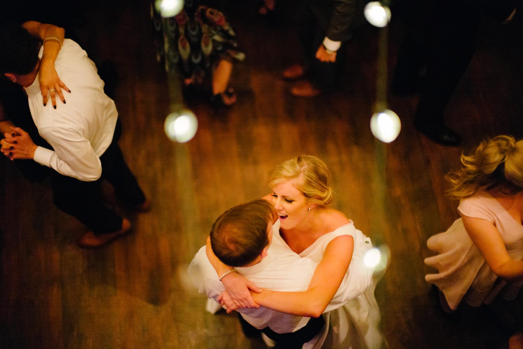 Couple first dance under edison style lightbulbs wedding reception best-houston-wedding-photographers