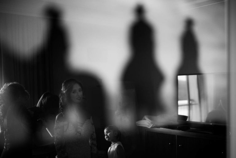 A bride and flower girls are reflected in a painting of Three horsemen at La Cantera