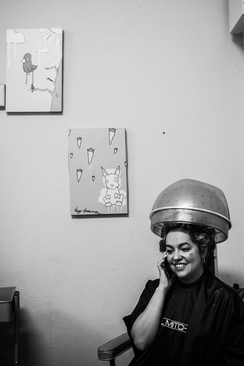 Bride smiling on phone with auto hair dryer above
