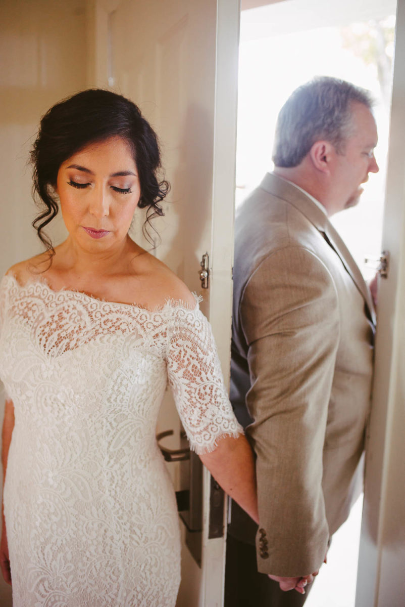 First look behind hotel door frame at Hotel Alsace Wedding Castroville Texas