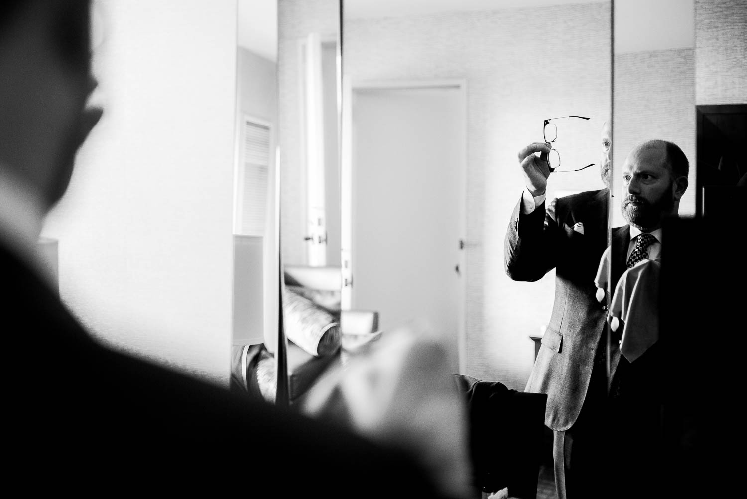 groom checks his glasses in mirror same-sex-wedding-marina-del-rey-marriott-los-angeles-leica-wedding-photographer-philip-thomas-marina del rey wedding