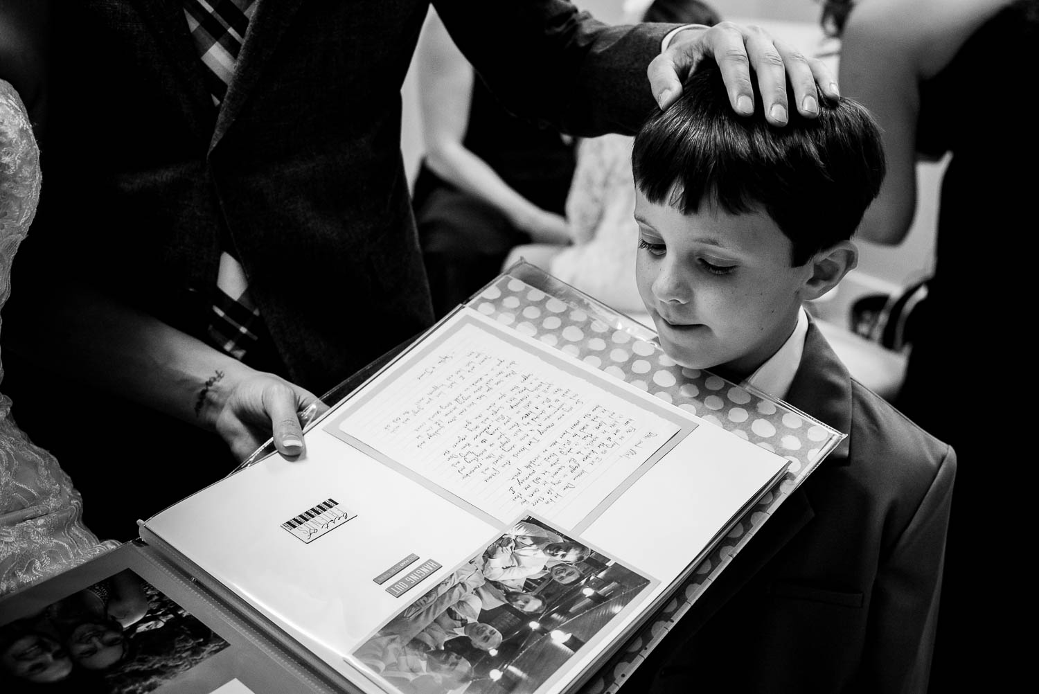 Boy looks at special wedding book the-lyceum-wedding-leica-wedding-photographer-philip-thomas