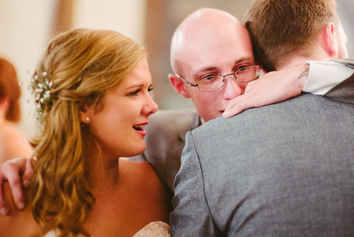 Brother of groom hugs in am emtional embrace as bride tears up wedding reception the-lyceum-wedding-leica-wedding-photographer-philip-thomas