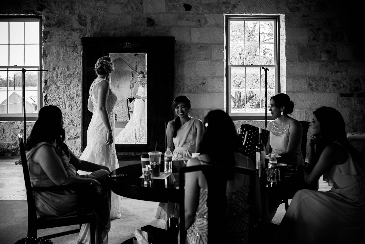 Bride checks herself in the mirror as friends sit a table at ingenhuett-on-high-wedding_leslie_omar-leica-wedding-photographer-philip-thomas - Best of wedding 2017 The Knot