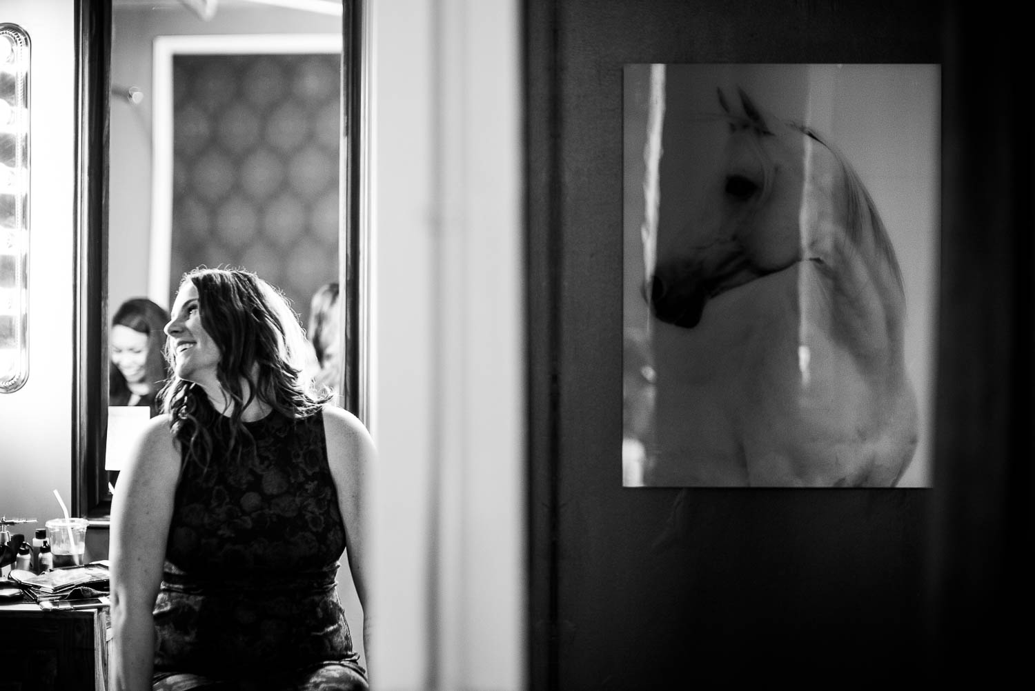 Sister of the bride looks toward the bride in the getting ready room at The Astorian, Houston, Texas.