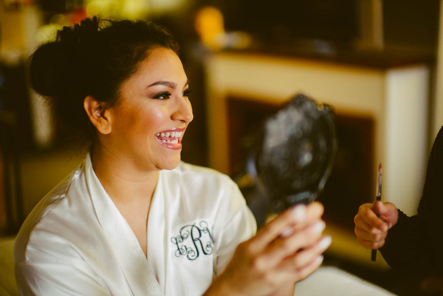 brides smiles as she looks in mirror at immaculate-heart-of-mary-church-philip-thomas-photography