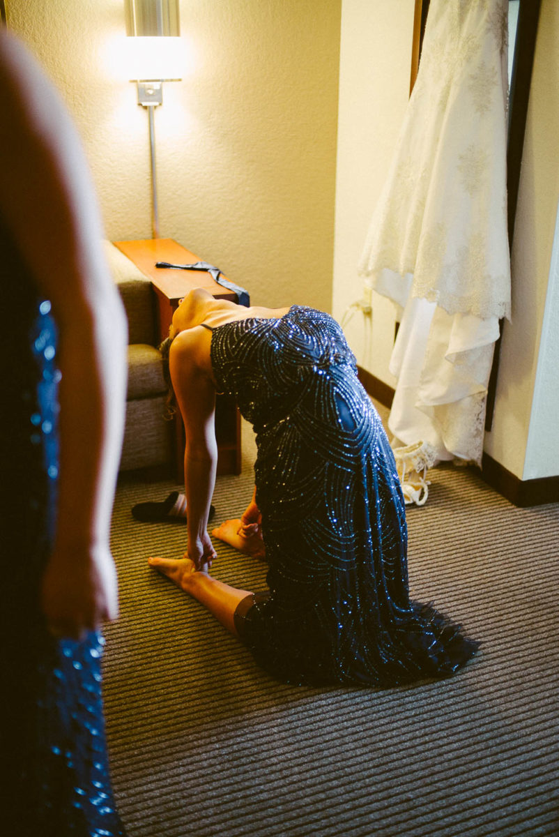 A bridesmaids exercises stretching her back