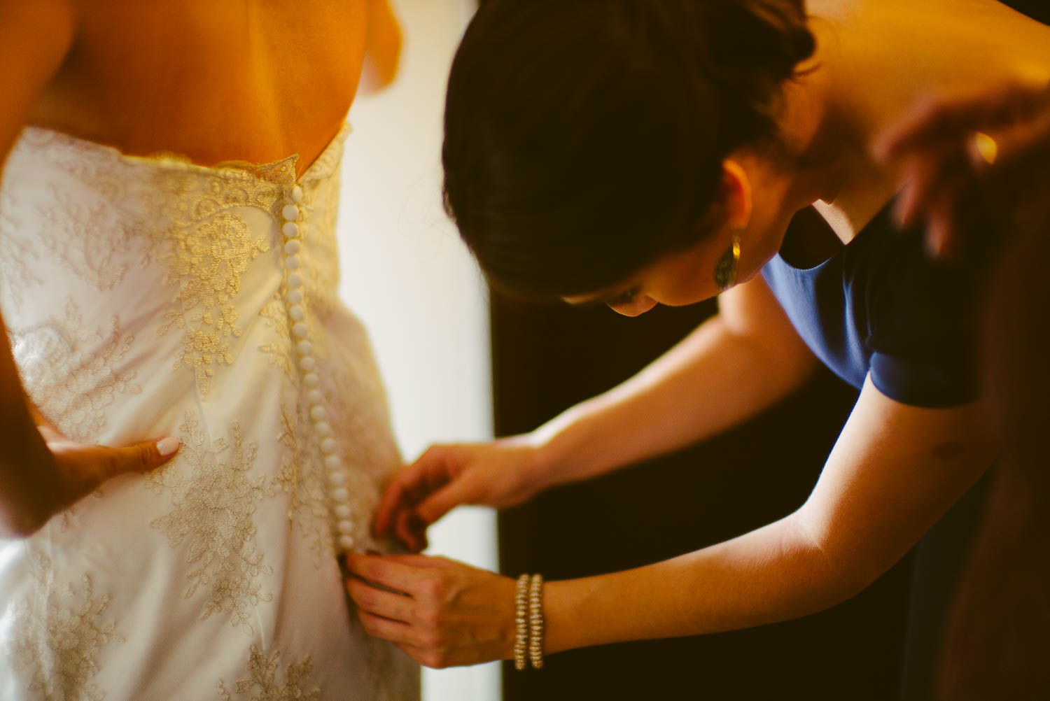 Buttoning the wedding dress at Hyatt Place San Antonio Texas