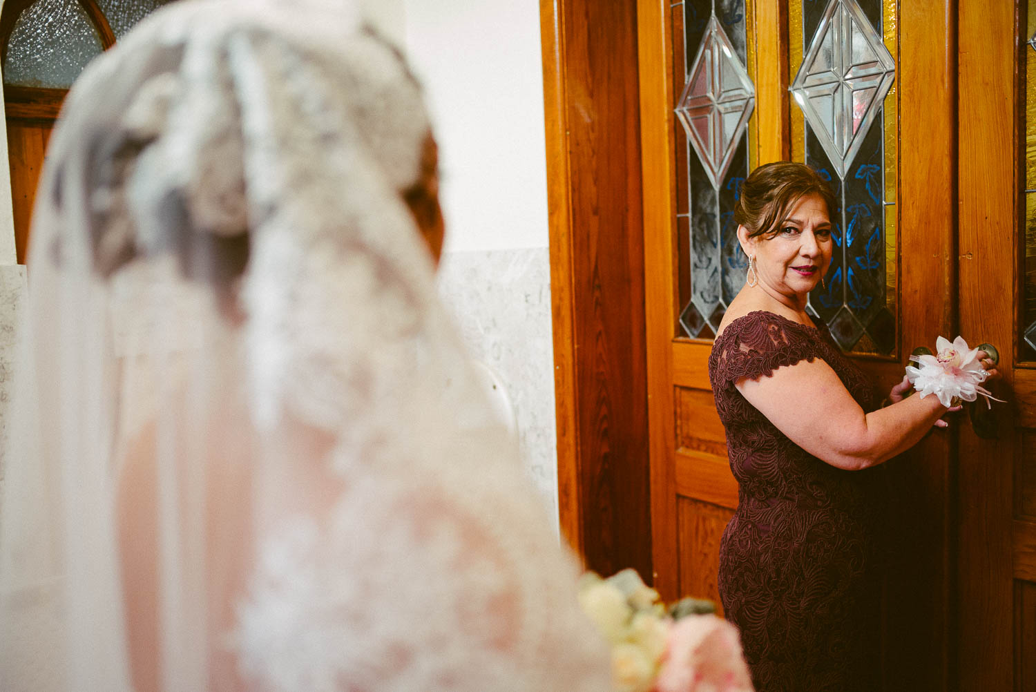 Mother of the bride looks back at her daughter before opening the doors for the ceremony at immaculate-heart-of-mary-church-philip-thomas-photography